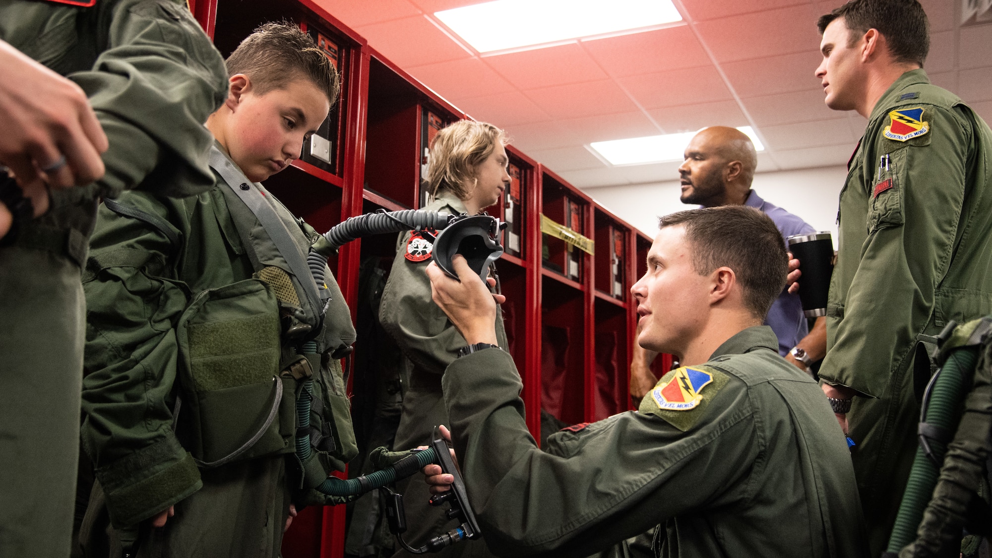 1st Lt. Matthew Brown shows Cole Lucas aircrew flight equipment May 24, 2018, at Hill Air Force Base, Utah. Eight children and their parents from Make-A-Wish Utah visited Hill for the "Pilot for a Day" program. The children toured the base, visited with pilots and "flew" in an F-35A cockpit trainer during the event. (U.S. Air Force photo by R. Nial Bradshaw)