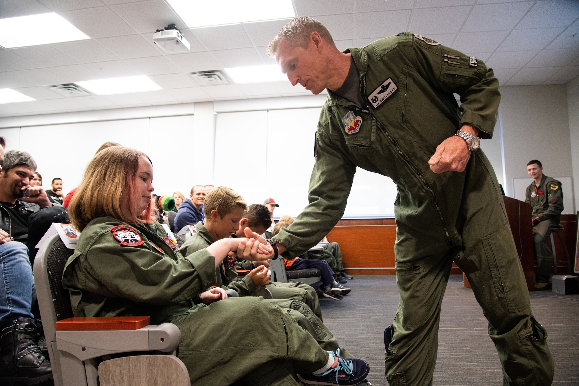 Col. Jason Rueschoff coins Michelle McConnell, May 24, 2018, at Hill Air Force Base, Utah. Eight children and their parents from the Make-A-Wish Foundation visited Hill for the "Pilot for a Day" program. The children toured the base, visited with pilots and "flew" in an F-35A cockpit trainer during the event. (U.S. Air Force photo by R. Nial Bradshaw)