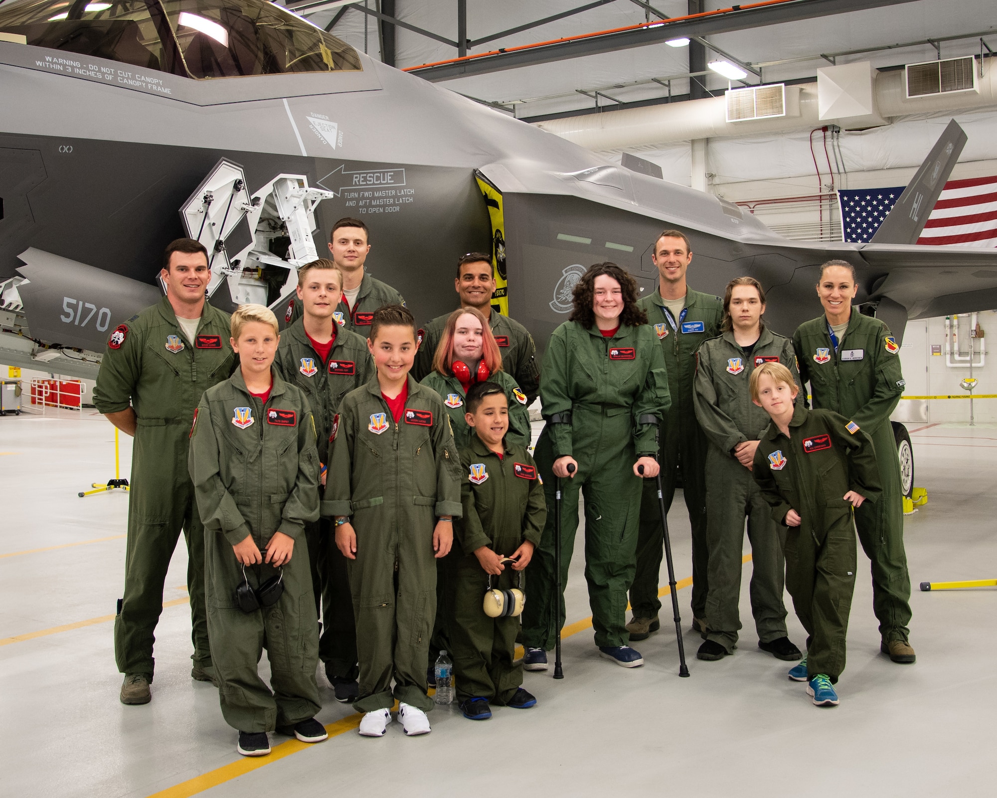 Children from Make-A-Wish Utah pose for a photo with F35A pilots, May 24, 2018, at Hill Air Force Base, Utah. Eight children and their parents from the Make-A-Wish visited Hill for the "Pilot for a Day" program. The children toured the base, visited with pilots and "flew" in an F-35A cockpit trainer during the event. (U.S. Air Force photo by R. Nial Bradshaw)
