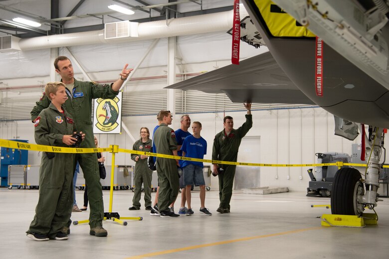 Capt. Timothy Six speaks with Tate Empey, May 24, 2018, at Hill Air Force Base, Utah. Eight children and their parents from Make-A-Wish Utah visited Hill for the "Pilot for a Day" program. The children toured the base, visited with pilots and "flew" in an F-35A cockpit trainer during the event. (U.S. Air Force photo by R. Nial Bradshaw)