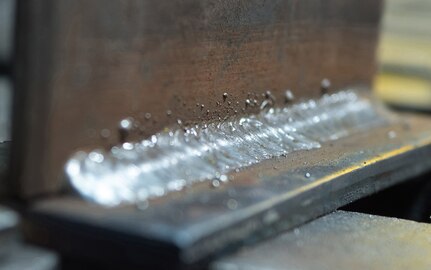 A welded metal plate rests on a bench in the metals fabrication shop on Joint Base Elmendorf-Richardson, Alaska, May 9, 2018, after an Airman worked on it. Aircraft Metals Technology Airmen measure broken or worn parts, draw working sketches, make templates, perform precision grinding remove poisonous or corrosive deposits from parts, and write programs for machines using manual and computer-aided manufacturing.