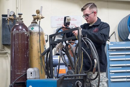 Airman Dalton Sturtz, a native of Seguin, Texas, an aircraft metals technology journeyman assigned to the 3rd Maintenance Squadron, puts his equipment away after welding in the metals fabrication shop on Joint Base Elmendorf-Richardson, Alaska, May 9, 2018. Aircraft Metals Technology Airmen measure broken or worn parts, draw working sketches, make templates, perform precision grinding remove poisonous or corrosive deposits from parts, and write programs for machines using manual and computer-aided manufacturing.