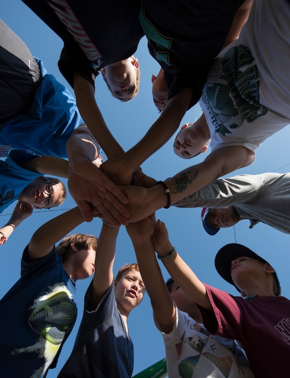 U.S. Air Force Capt. Joshua Gradaille, 33rd Fighter Wing executive officer, and the rest of the Ranger's coaching staff and team, huddle before a practive May 10, 2018, at Eglin Air Force Base, Fla. Gradaille began coaching with hopes of the lifelong lessons that children can learn from baseball. Eventually, Gradaille learned that his impact goes beyond the diamond and into their daily lives. (U.S. Air Force photo by Staff Sgt. Peter Thompson)