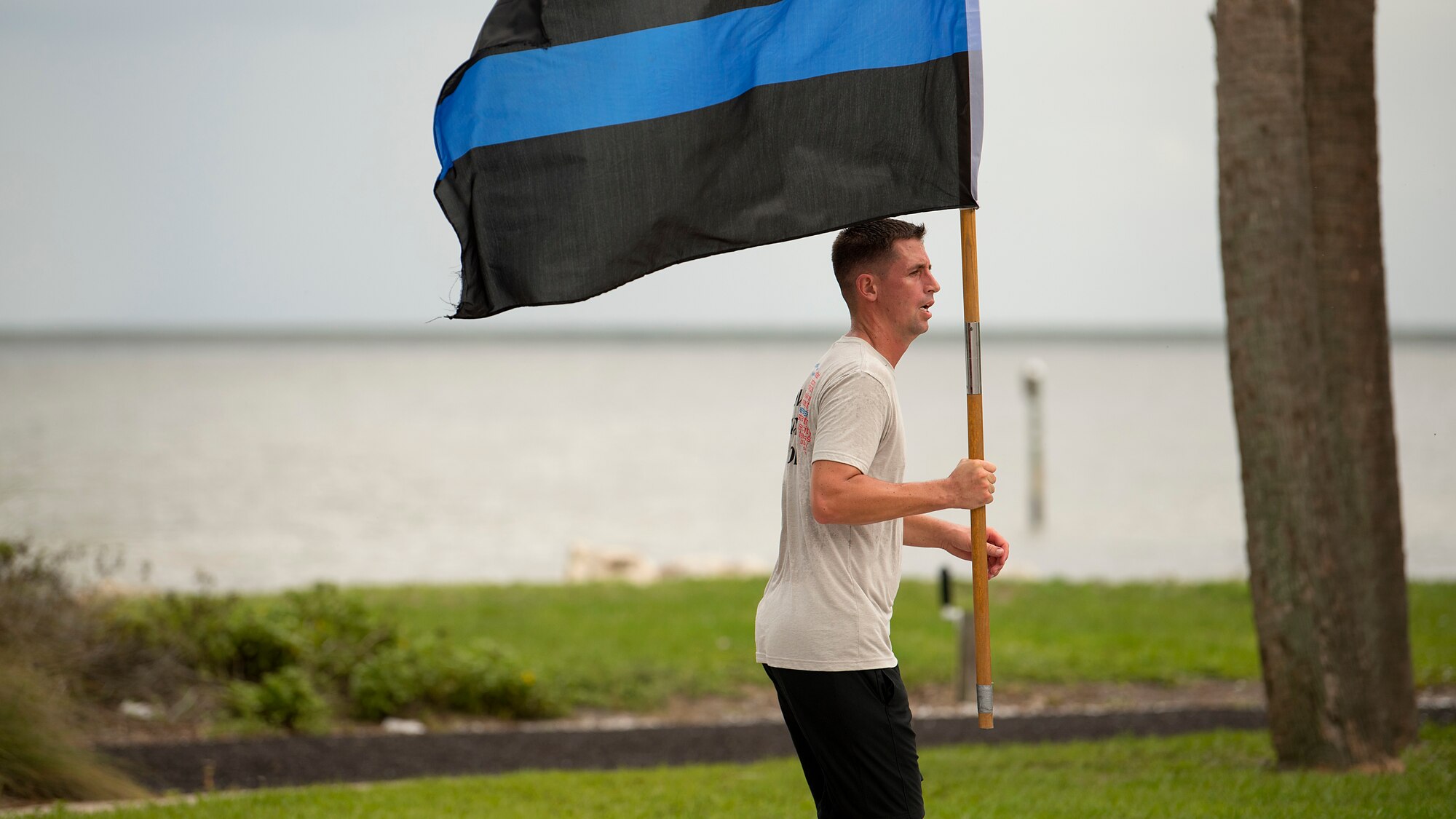 U.S. Air Force Tech. Sgt. Jeremy Stull, a flight chief assigned to the 6th Security Forces Squadron, runs with a thin blue line flag after a 24-hour vigilance run at MacDill Air Force Base, Fla. MacDill celebrated Police Week with a variety of events to commemorate the contributions and sacrifices of law enforcement officials around the world.