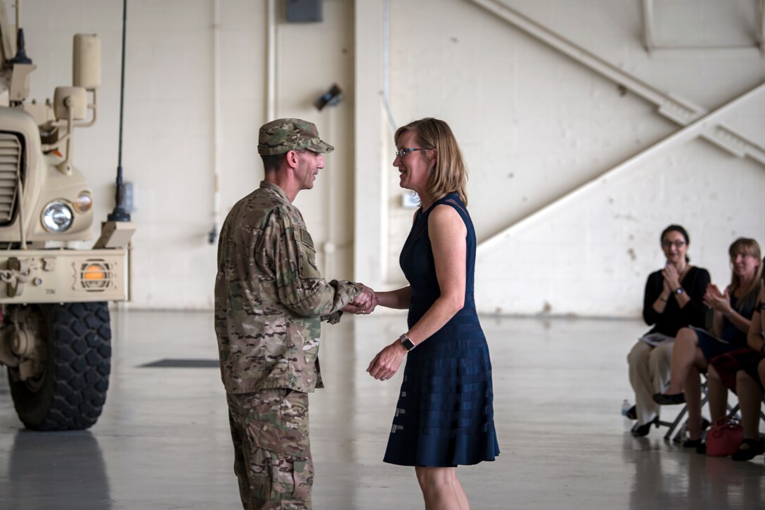 U.S. Air Force Maj. Gen. Scott J. Zobrist, left, 9th Air Force commander, coins JoAnne Valenzia, Key Spouse Mentor for the 93d Air Ground Operations Wing and spouse of Col. Jeffrey Valenzia, 93d AGOW outgoing commander, during a change of command ceremony, May 23, 2018, at Moody Air Force Base, Ga. Zobrist coined Mrs. Valenzia for her work as a mentor in the Key Spouse Program. The Key Spouse Program is an official unit and family program that promotes partnerships with Key Spouses, unit leadership, families, the Airman and Family Readiness Center and other community and helping agencies. (U.S. Air Force photo by Airman 1st Class Eugene Oliver)