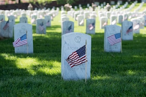 Flags placed in front of headstone at Arlington National Cemetery.