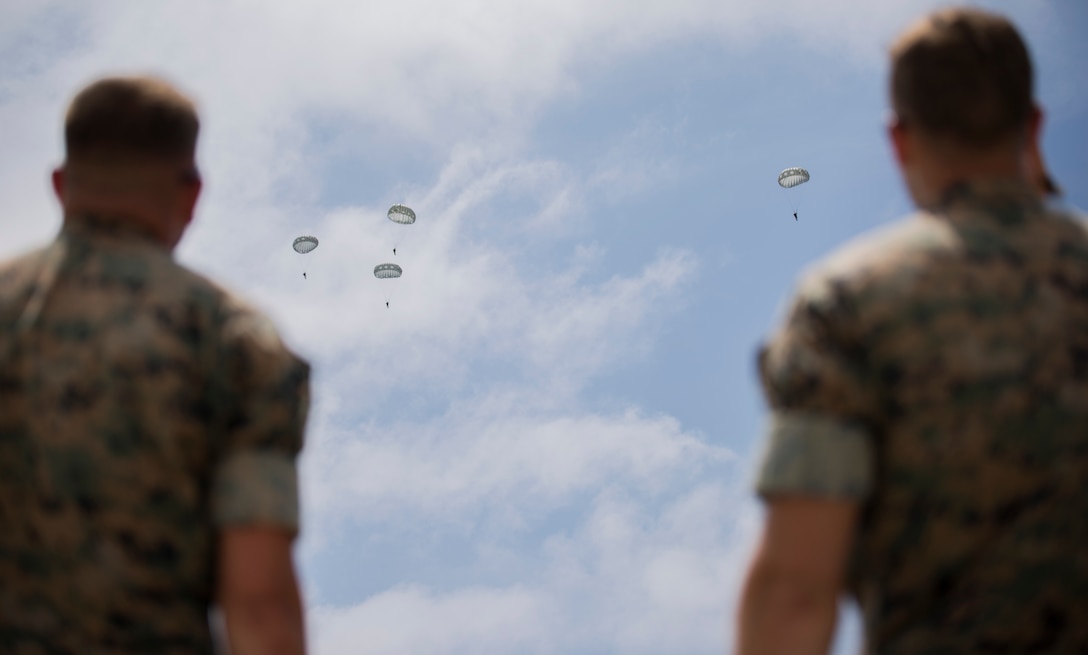 Marines with 3rd Air Delivery Platoon, Landing Support Company, 3rd Transportation Support Battalion, 3rd Marine Logistics Group, monitor the jump paths of Marines free-falling from a C-130 May 22, 2018, on Ie Shima, Okinawa, Japan. The Marines conducted air drop operations dropping a type-five platform, door bundles, free fall and static line jumpers, and the Polaris MRZR onto the island. 3rd MLG Marines worked alongside Marines with 3rd Reconnaissance Battalion, 3rd Marine Division, during the regularly scheduled training evolution to complete their first ever successful drop of a Polaris MRZR from a C-130.