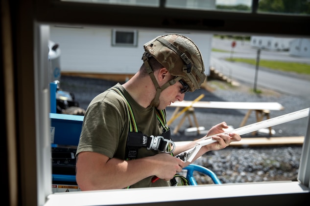 U.S. Marine Lance Cpl. Wyatt Miller, combat engineer with Engineer Company C, 6th Engineer Support Battalion, 4th Marine Logistics Group, cuts a panel of siding for the window frame at a construction site during exercise Red Dagger at Fort Indiantown Gap, Pa., May 23, 2018.