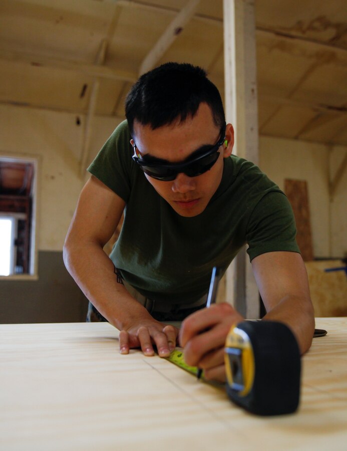 U.S. Marine Lance Cpl. Thang Q. Duong, squad leader with Headquarters and Service Company, 6th Engineer Support Battalion, 4th Marine Logistics Group, measures a piece of plywood at a construction site during exercise Red Dagger at Fort Indiantown Gap, Pa., May 23, 2018. Exercise Red Dagger is a bilateral training exercise that gives Marines an opportunity to exchange tactics, techniques and procedures as well as build working relationships with their British counterparts. (U.S. Marine Corps photo by Sgt. Melanie Wolf/Released)