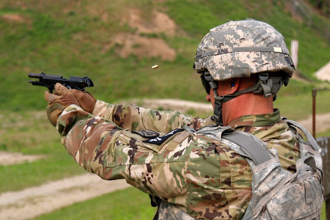 A soldier fires his pistol engaging a target at the stress shoot event.