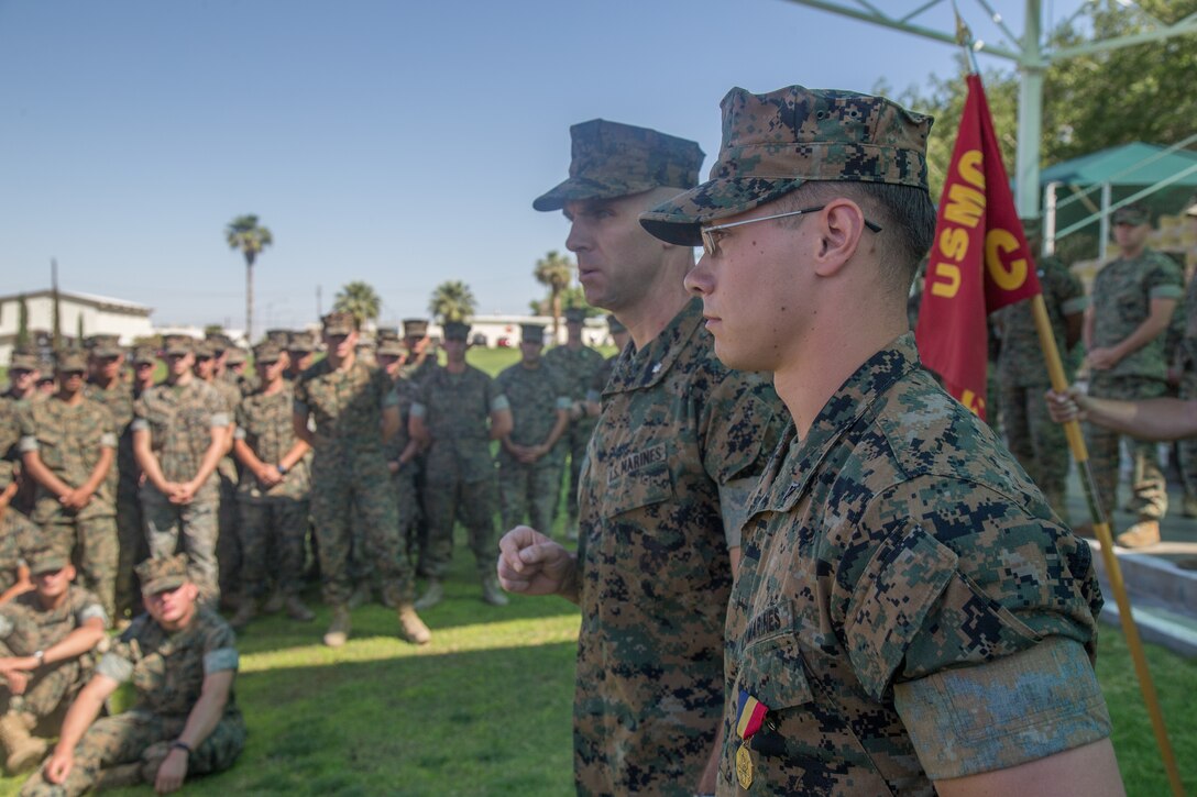 Lance Cpl. Tucker Watson-Veal, scout, 3rd Light Armored Reconnaissance Battalion, stands next to Lt. Col. John S. Kinitz, commanding officer, 3rd LAR, as he addresses the battalion after a ceremony at Lance Cpl. Torrey L. Gray Field aboard the Marine Corps Air Ground Combat Center, Twentynine Palms, Calif., May 24, 2018. Watson-Veal was awarded the Navy and Marine Corps Medal after rescuing a drowning person from rapid currents while on leave in 2016. (U.S. Marine Corps photo by Lance Cpl. Preston L. Morris)