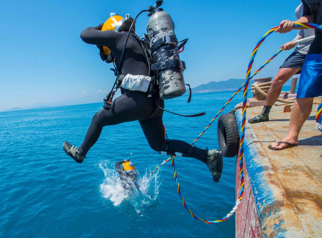 Army divers from the 7th Engineer Dive Detachment jump into the water during an underwater recovery mission near Nha Trang, Vietnam.