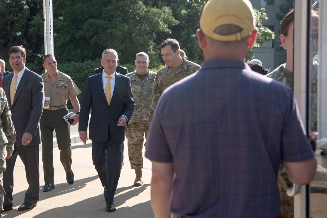 Defense Secretary James N. Mattis walks with other people.