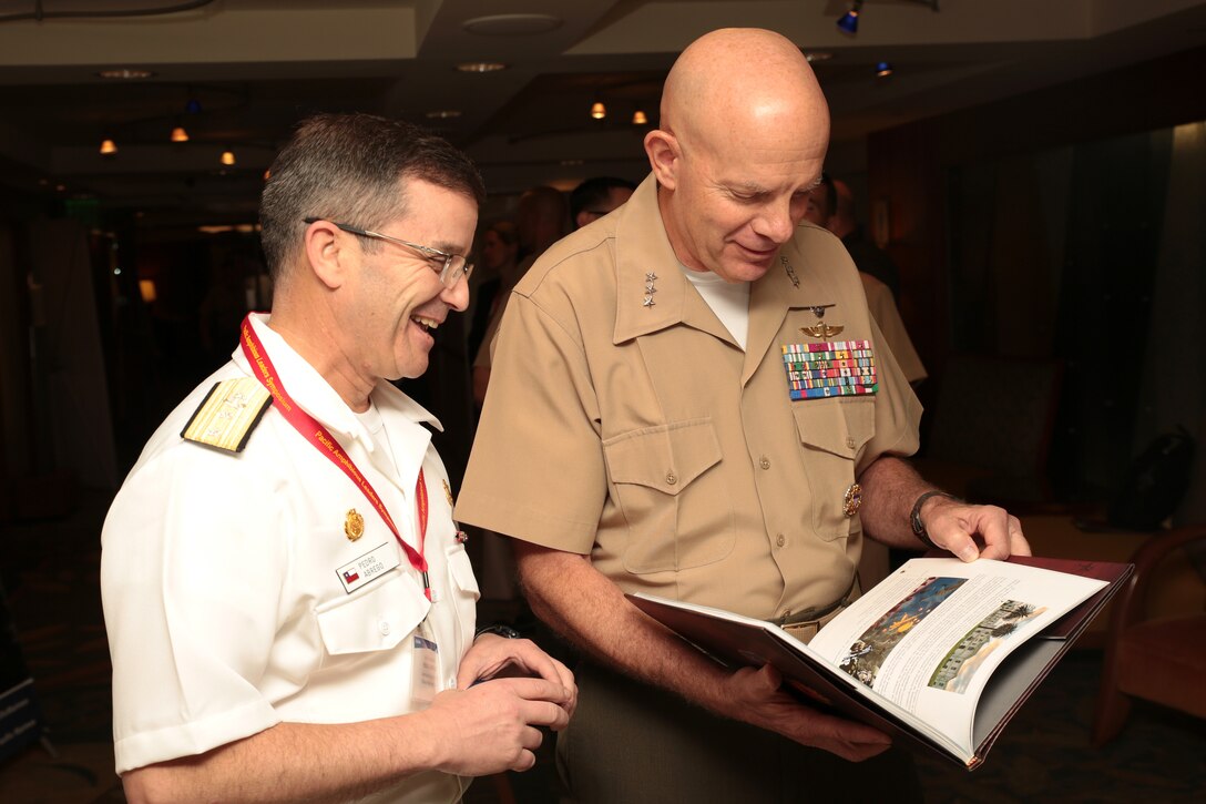 Chilean Marine Corps Rear Adm. Pedro Abrego Martinez, commanding general, Chilean Marine Corps, presents U.S. Marine Corps Lt. Gen. David H. Berger, commander, U.S. Marine Corps Forces, Pacific, with a gift during the Pacific Amphibious Leaders Symposium (PALS) 2018 in Honolulu, Hawaii, May 23, 2018. Events such as PALS helps to strengthen our interoperability and working relationships across a wide range of military operations – from humanitarian assistance and disaster relief to complex expeditionary operations. (U.S. Marine Corps photo by Cpl. Maximiliano Rosas)