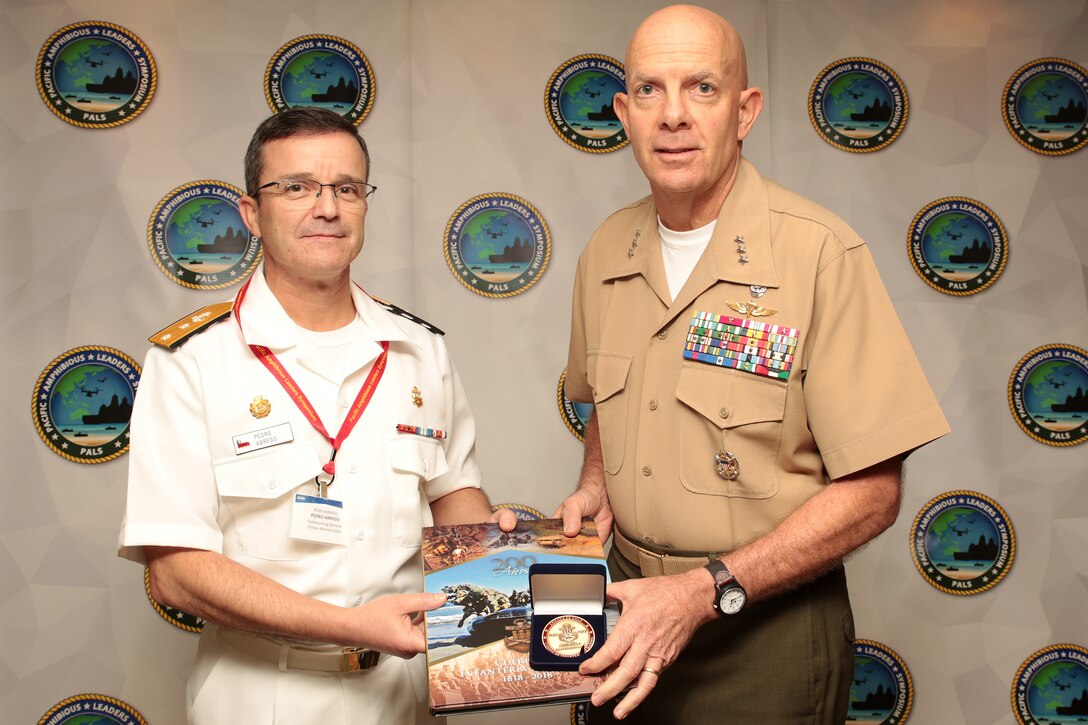 Chilean Marine Corps Rear Adm. Pedro Abrego Martinez, commanding general, Chilean Marine Corps, presents U.S. Marine Corps Lt. Gen. David H. Berger, commander, U.S. Marine Corps Forces, Pacific, with a gift during the Pacific Amphibious Leaders Symposium (PALS) 2018 in Honolulu, Hawaii, May 23, 2018. Events such as PALS helps to strengthen our interoperability and working relationships across a wide range of military operations – from humanitarian assistance and disaster relief to complex expeditionary operations. (U.S. Marine Corps photo by Cpl. Maximiliano Rosas)