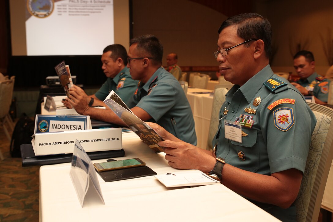 Indonesian Navy Capt. Fnu Sawa, right, commanding officer, Amphibious Squadron, Eastern Fleet, looks over the Pacific Amphibious Leaders Symposium (PALS) photo book during PALS in Honolulu, Hawaii, on May 24, 2018. PALS brings together senior leaders of allied and partner militaries with significant interest in the security and stability of the Indo-Pacific region to discuss key aspects of maritime/amphibious operations, capability development, crisis response and interoperability. (U.S. Marine Corps photo by Cpl. Maximiliano Rosas)