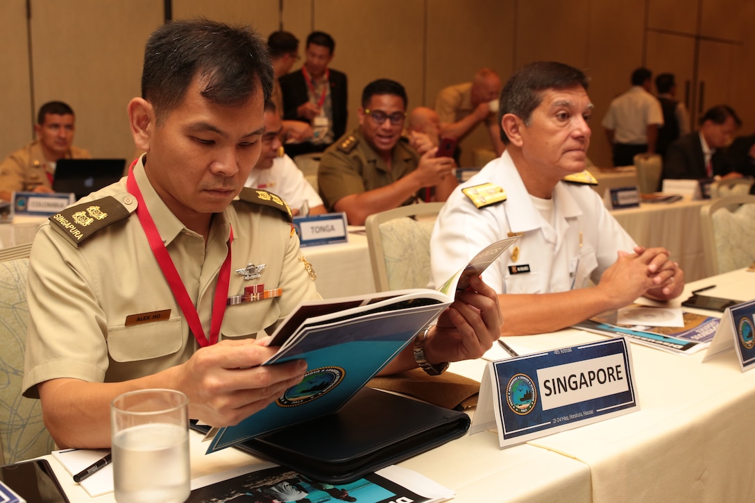 Singapore Armed Forces Lt. Col. Alex Ho, Liasion Officer to the U.S. Marine Corps, flips through the Pacific Amphibious Leaders Symposium (PALS) photo book during PALS in Honolulu, Hawaii, May 23, 2018. PALS brings together senior leaders of allied and partner militaries with significant interest in the security and stability of the Indo-Pacific region to discuss key aspects of maritime/amphibious operations, capability development, crisis response and interoperability. (U.S. Marine Corps photo by Cpl. Maximiliano Rosas)