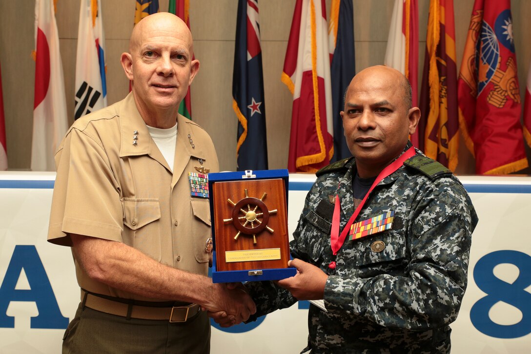 U.S. Marine Corps Lt. Gen. David H. Berger, commander, U.S. Marine Corps Forces, Pacific, left, receives a gift from Rear Adm. Udeni Indranatha Serasinghe, Director General Land Operation and Director, Sri Lanka Navy Infantry and Navy Marine, at the close of the Pacific Amphibious Leaders Symposium (PALS) in Honolulu, Hawaii, May 24, 2018. PALS brings together senior leaders of allied and partner militaries with significant interest in the security and stability of the Indo-Pacific region to discuss key aspects of maritime/amphibious operations, capability development, crisis response and interoperability. (U.S. Marine Corps photo by Cpl. Maximiliano Rosas)