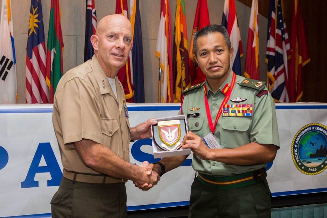 Malaysian Brig. Gen. Tengku Muhammad Fauzi Tengku Ibrahim, commander, 10th Brigade, gives a gift to U.S. Marine Corps Lt. Gen. David H. Berger, commander, U.S. Marine Corps Forces, Pacific, during the Pacific Amphibious Leaders Symposium (PALS) 2018 in Honolulu, Hawaii, May 24, 2018. PALS brings together senior leaders of allied and partner militaries with significant interest in the security and stability of the Indo-Pacific region to discuss key aspects of maritime/amphibious operations, capability development, crisis response and interoperability. (U.S. Marine Corps photo by Cpl. Patrick Mahoney)