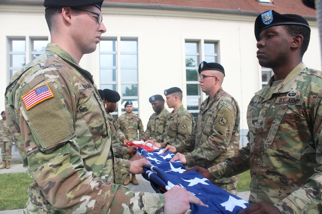 Soldiers fold an American flag.