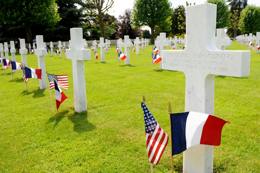Rows of crosses have American and French flags in front of them.