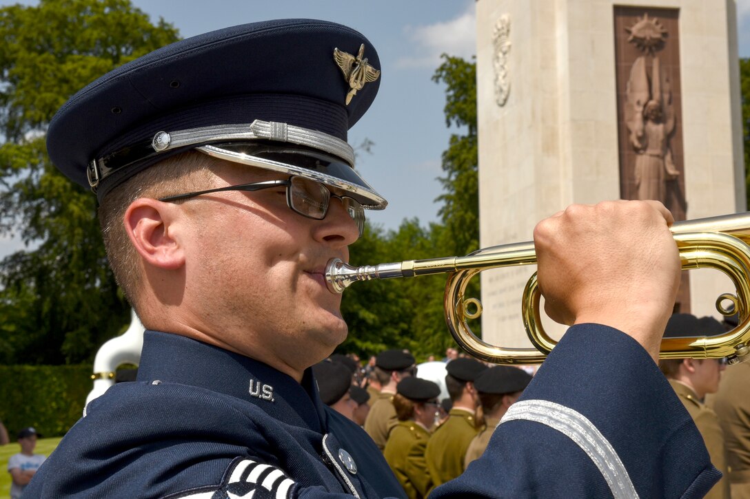 An airman plays a bugle.