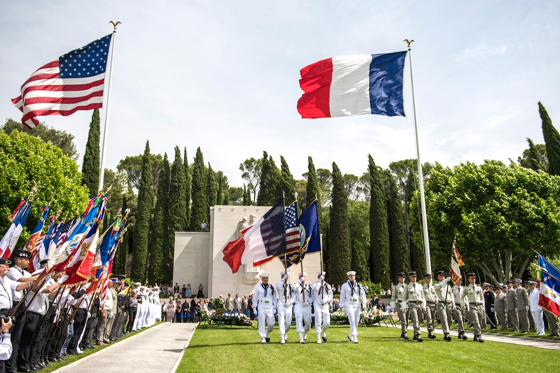 American and French service members march.