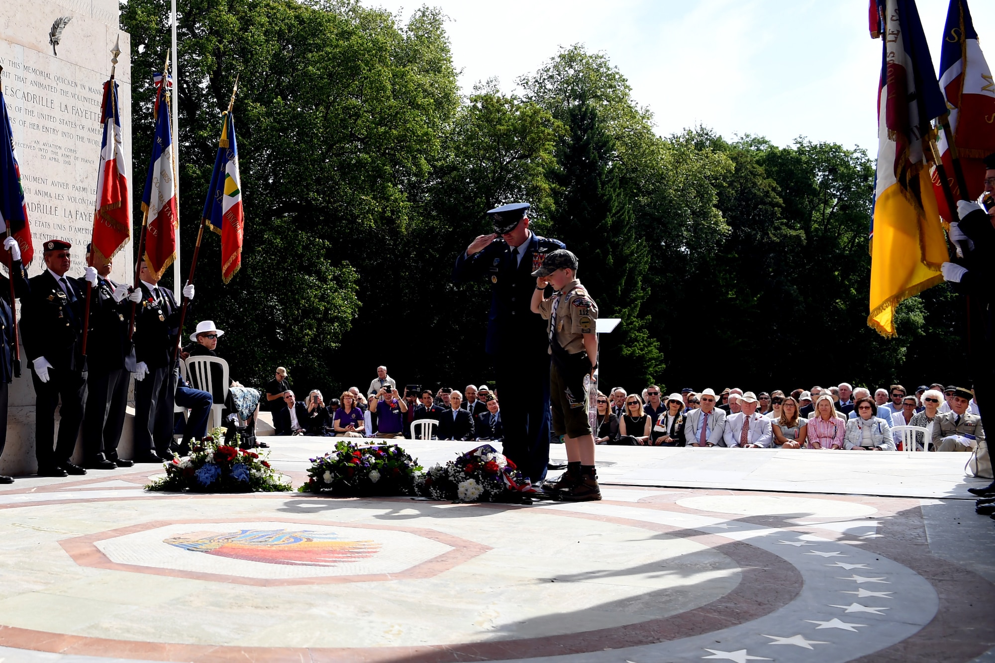 Gen. Wolters and a local boy scout salute the memorial wreath at Lafayette Escadrille Memorial.