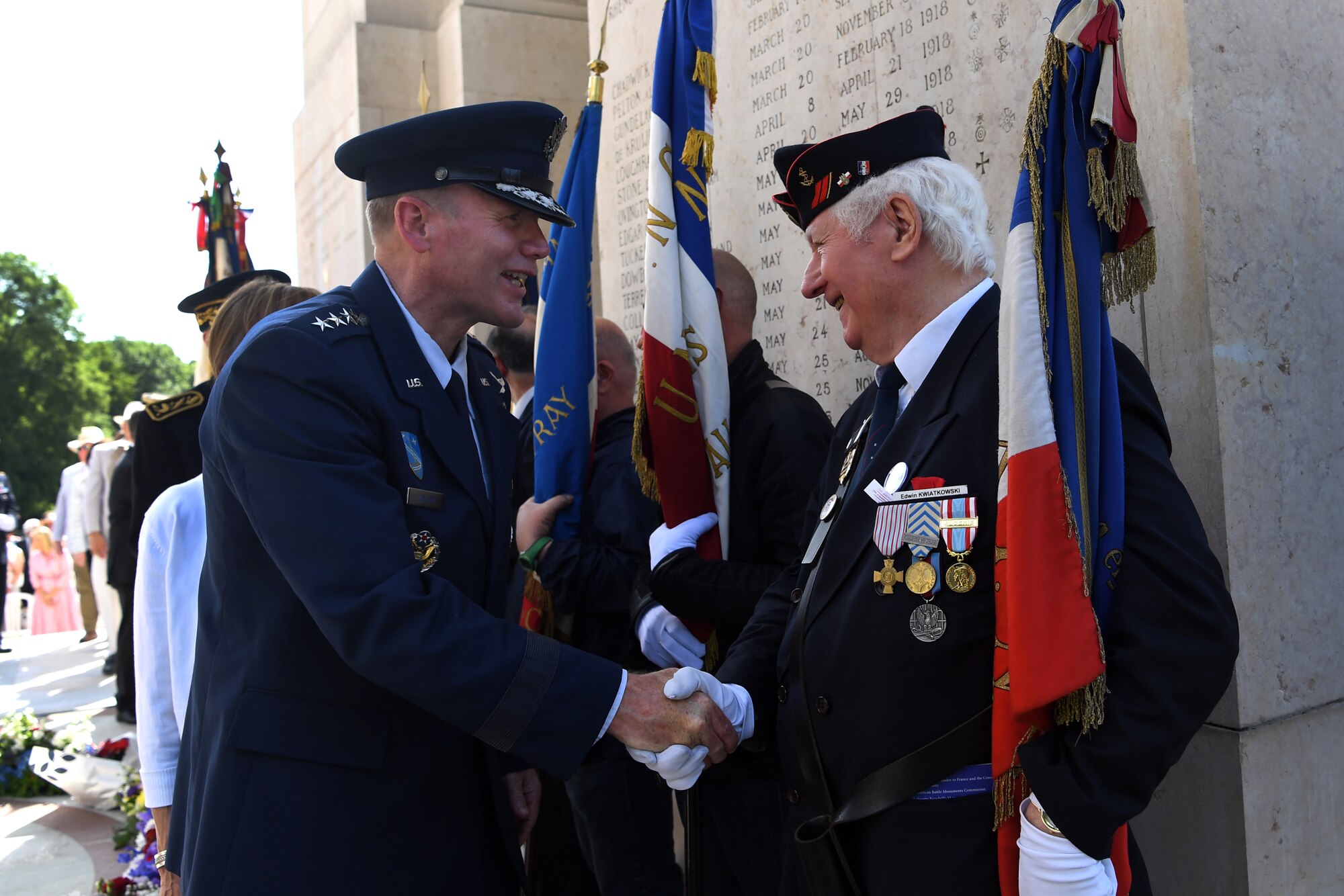 Gen. Wolters shakes hands with a flag bearer at Lafayette Escadrille Memorial.