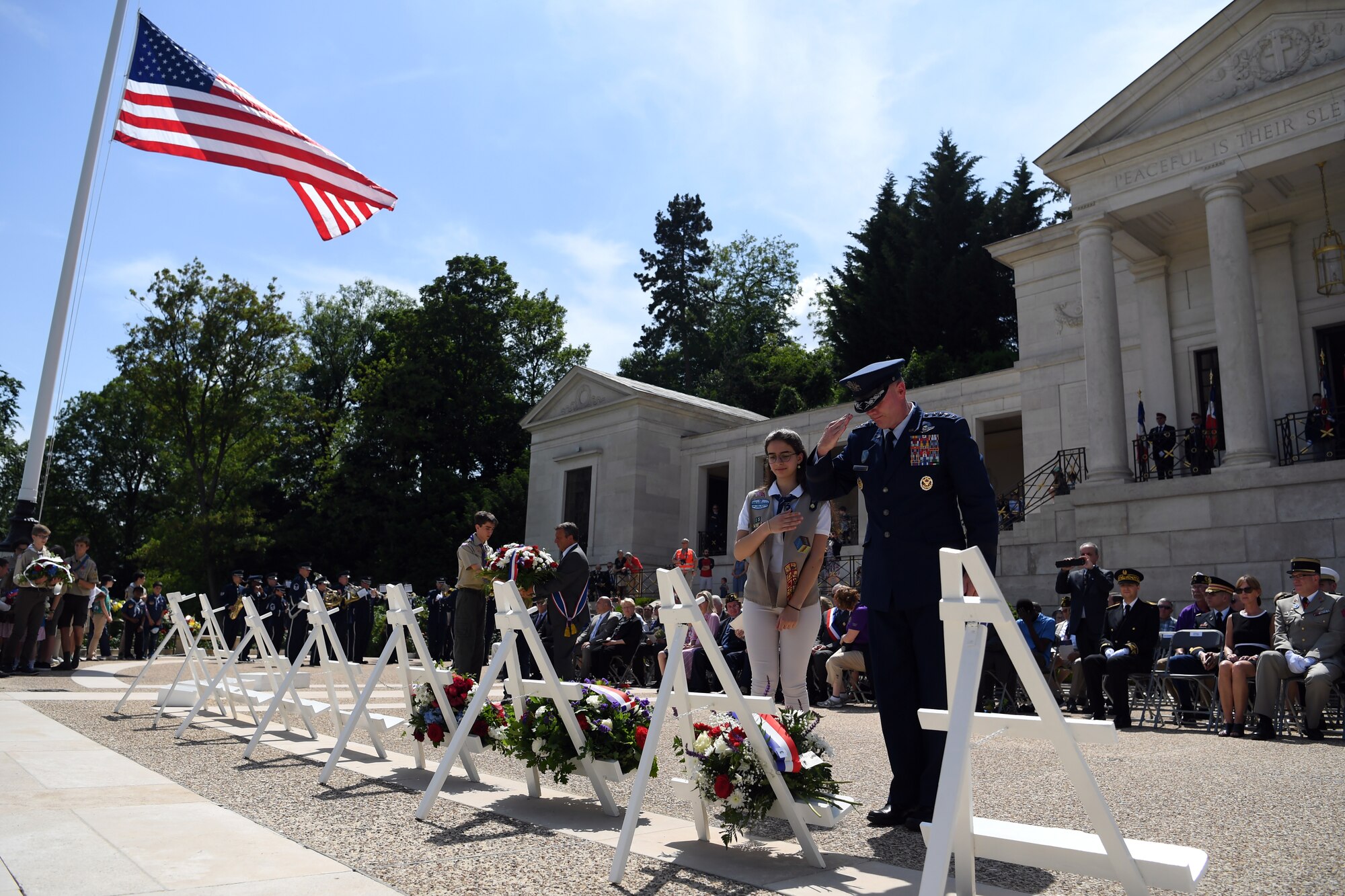 Gen. Wolters and girl scout salute the memorial wreath during memorial day ceremony at Suresnes American Cemetery.