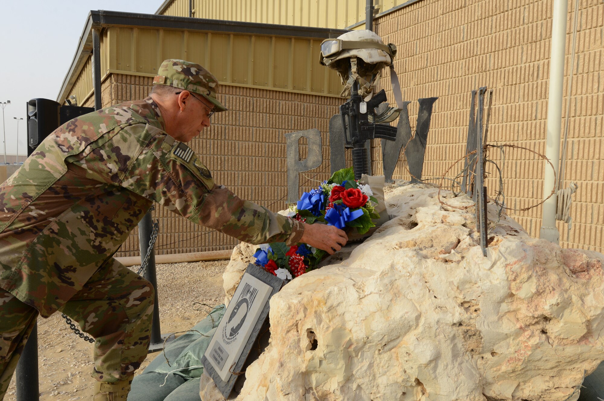 Col. David Buttrick, lead chaplin for the 379th Air Expeditionary Wing, places a wreath at the feet of a POW/MIA memorial during a Memorial Day ceremony at Al Udeid Air Base, Qatar, May 24, 2018. The ceremony also recognized and honored all those who gave the ultimate sacrifice for our freedom. (U.S. Air Force photo by 1st Lt. Katie Spencer)