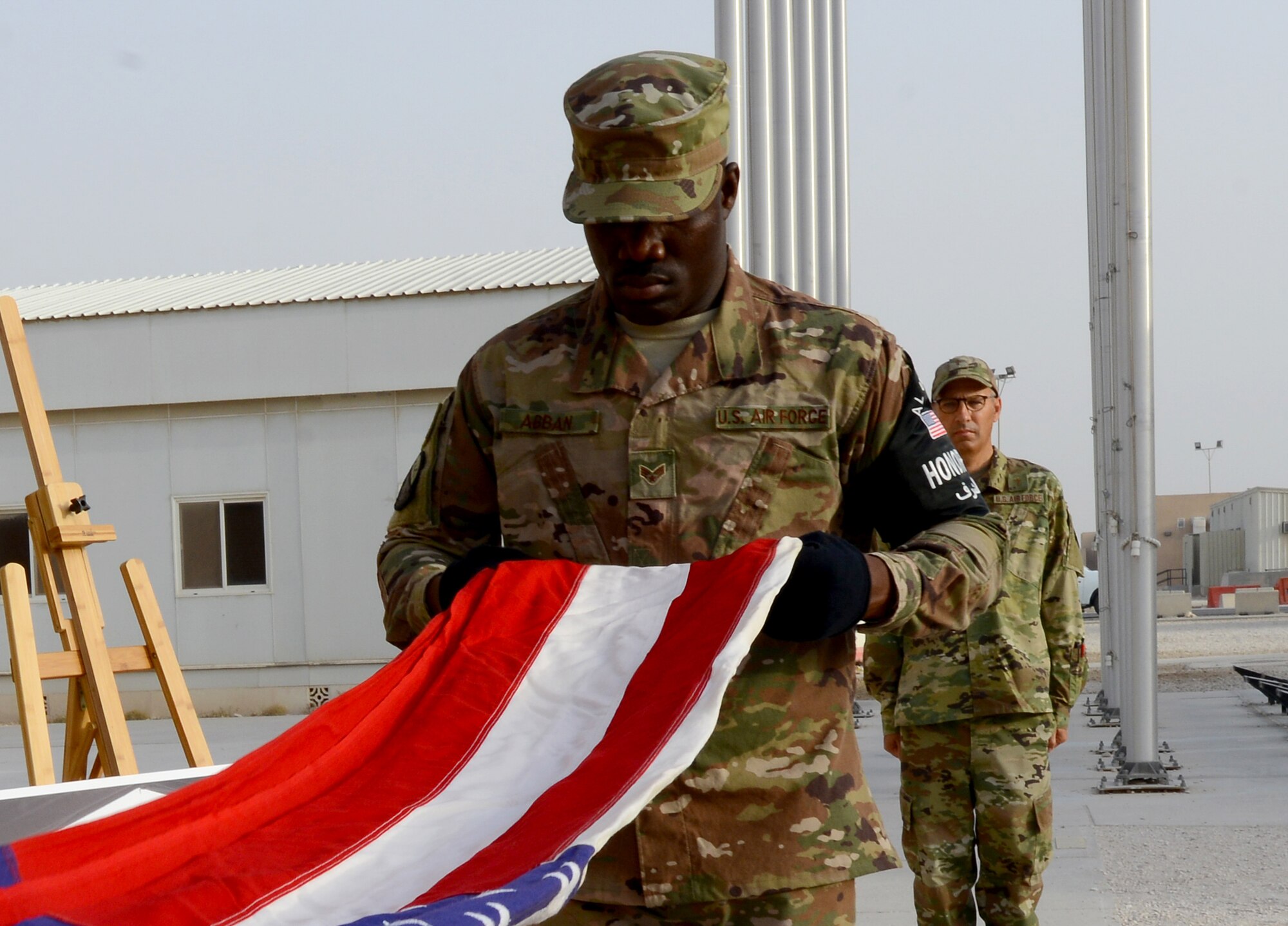 A member from the 379th Air Expeditionary Wing Honor Guard folds a flag during a Memorial Day ceremony at Al Udeid Air Base, Qatar, May 24, 2018. The ceremony also recognized and honored all those who gave the ultimate sacrifice for our freedom. (U.S. Air Force photo by 1st Lt. Katie Spencer)