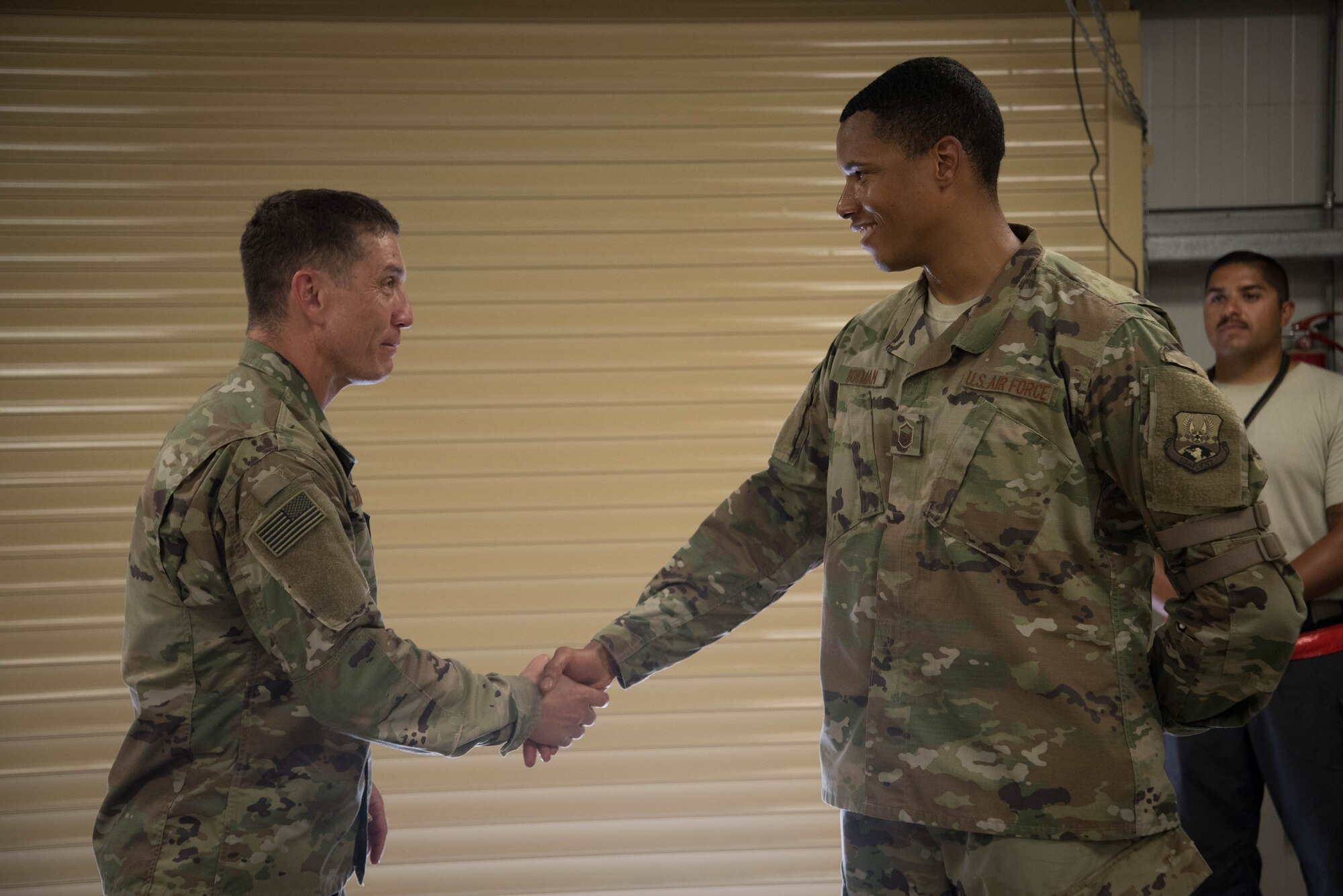U.S. Air Force Chief Master Sgt. Joseph Montgomery, U.S. Air Forces Central Command Chief, coins Master Sgt. Darik Bowman, 380th Expeditionary Maintenance Squadron, for his outstanding performance while deployed to Al Dhafra Air Base, May 25. (U.S. Air Force photo by Staff Sgt. Erica Rodriguez)