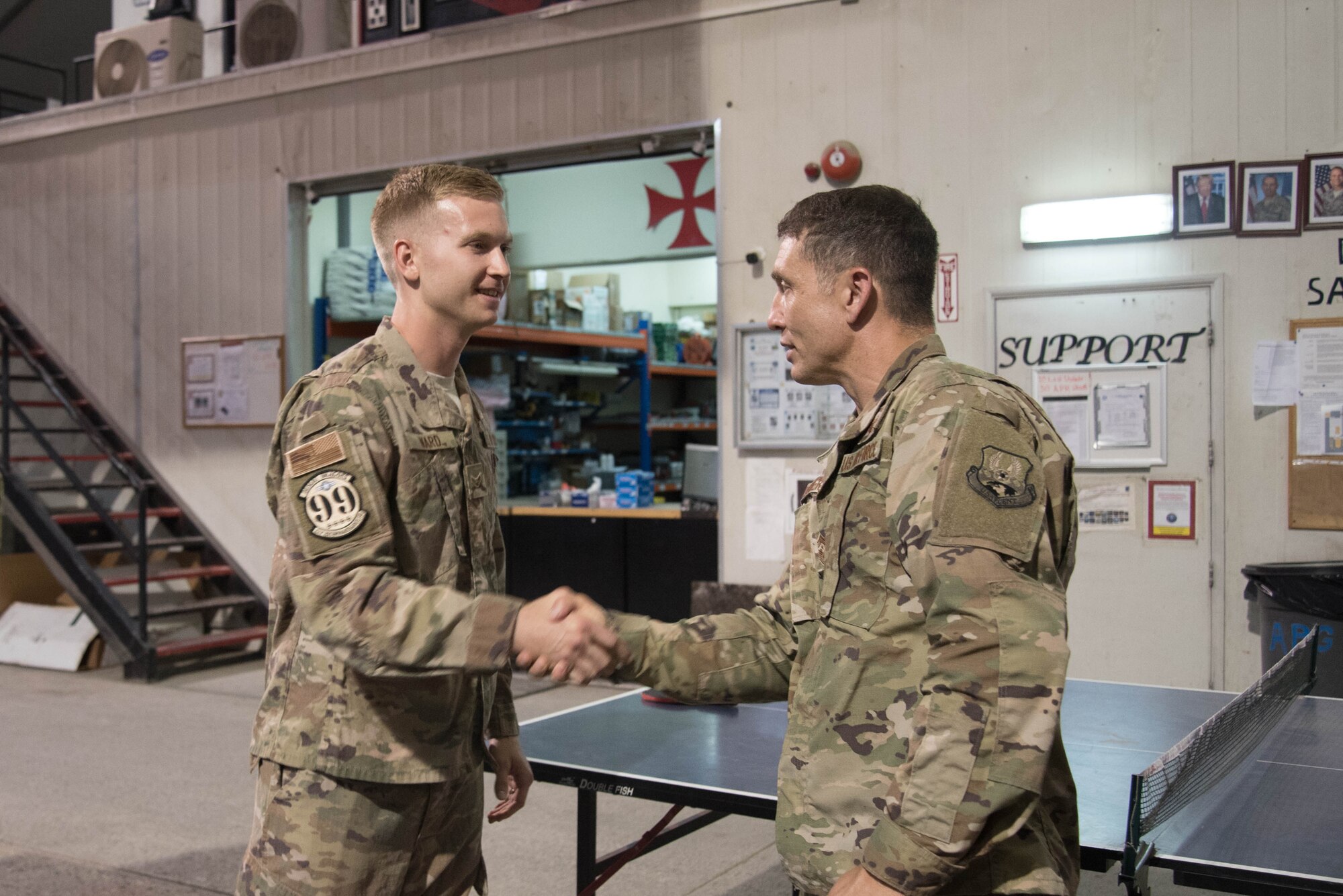 U.S. Air Force Chief Master Sgt. Joseph Montgomery, U.S. Air Forces Central Command Chief, coins Airman 1st Class Cole Ward, 380th Aircraft Maintenance Squadron U-2 Aircraft Maintenance Unit avionics technician, for his outstanding performance while deployed to Al Dhafra Air Base, May 25. (U.S. Air Force photo by Staff Sgt. Erica Rodriguez)