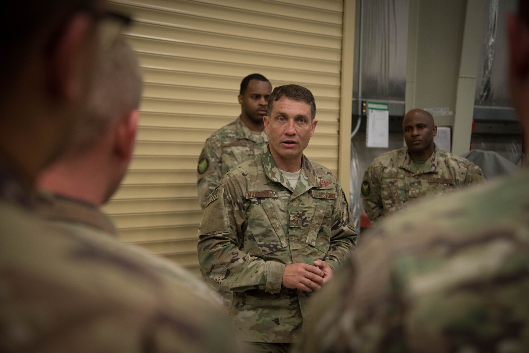 U.S. Air Force Chief Master Sgt. Joseph Montgomery, U.S. Air Forces Central Command Chief, speaks to 380th Expeditionary Maintenance Squadron members during his visit to Al Dhafra Air Base, May 25. Montgomery coined outstanding performers and briefed Airmen on the importance of their deployed mission. (U.S. Air Force photo by Staff Sgt. Erica Rodriguez)