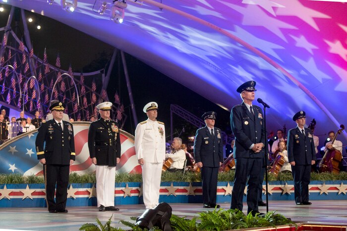 Military officers stand on a stage with the vice chairman of the Joint Chiefs of Staff.