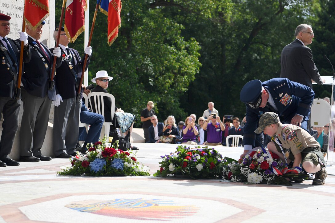 An Air Force officer and a boy scout lay a wreath.