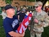 Retired Master Sgt. Gerald Sonnenberg passes out a flag to Command Chief Master Sgt. Chad Welch as these Airmen of the 932nd Airlift Wing remember fallen comrades at the Belleville Memorial Day parade, on May 28, 2018. The two sergeants, along with other wing members from various areas, walked approximately 1.5 miles and thanked the crowds as they progressed through the city.  The 932nd Airlift Wing is a 22nd Air Force unit, under the Air Force Reserve Command, and is located at Scott Air Force Base, Ill.(U.S. Air Force photo by Lt. Col. Stan Paregien)
