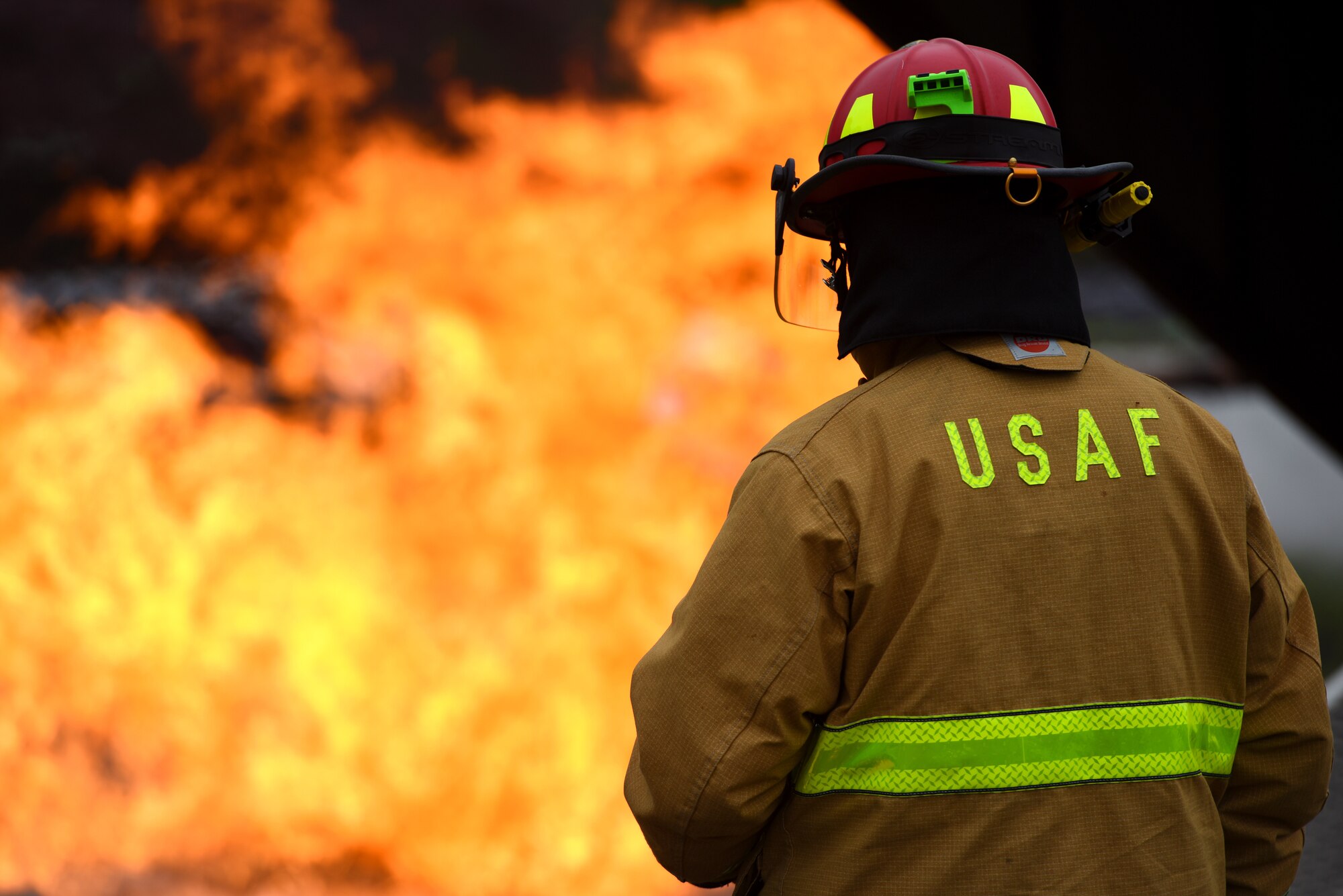 A U.S. Airman assigned to the 51st Civil Engineer Squadron fire and emergency services flight observes as U.S. Air Force and South Korean firefighters combat a simulated aircraft fire during an exercise at the Korean National University of Welfare in Pyeongtaek, Republic of Korea, May 17, 2018.