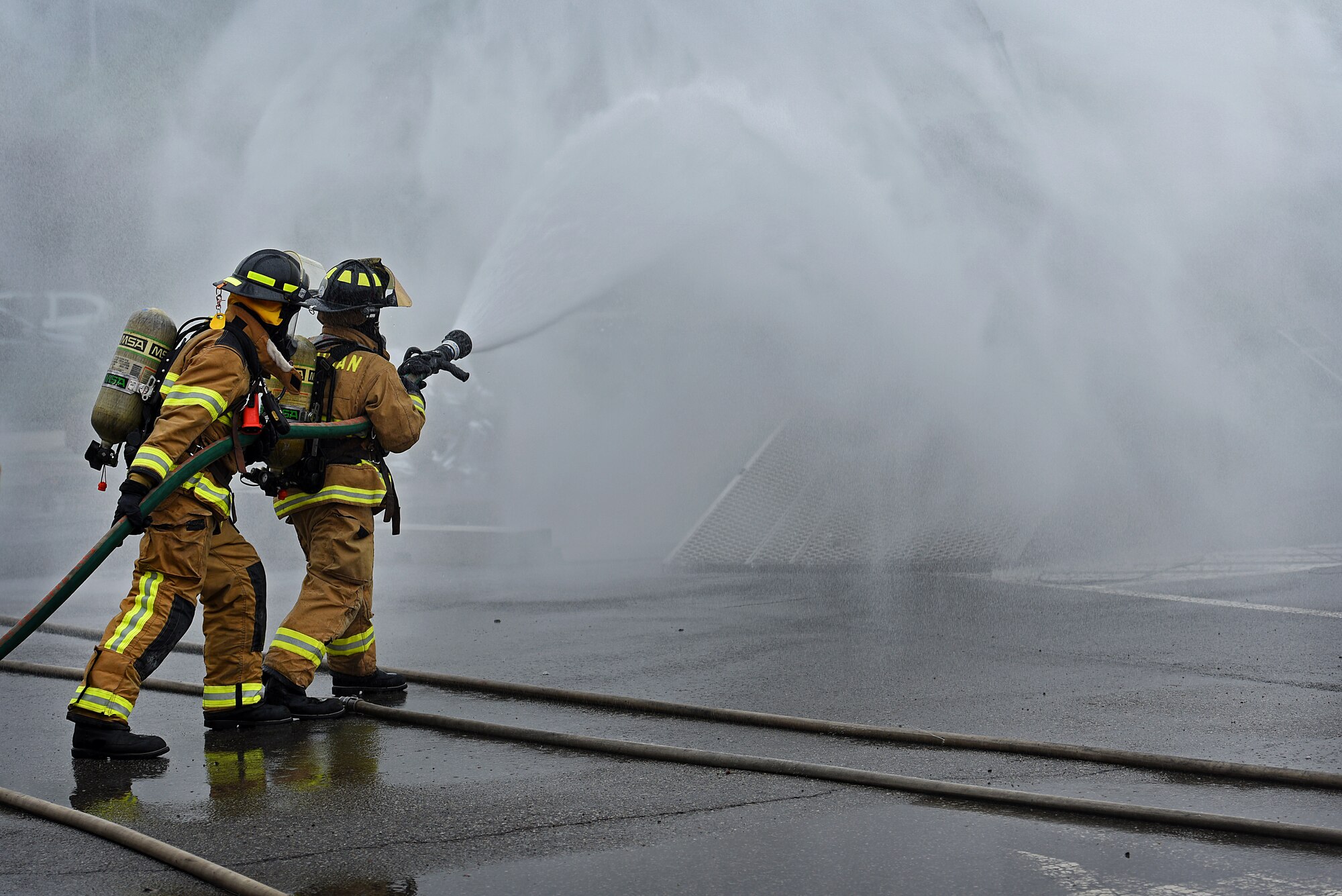 U.S. Airmen assigned to the 51st Civil Engineer Squadron fire and emergency services flight assist South Korean firefighters in combating a simulated aircraft fire during an exercise at the Korean National University of Welfare in Pyeongtaek, Republic of Korea, May 17, 2018.