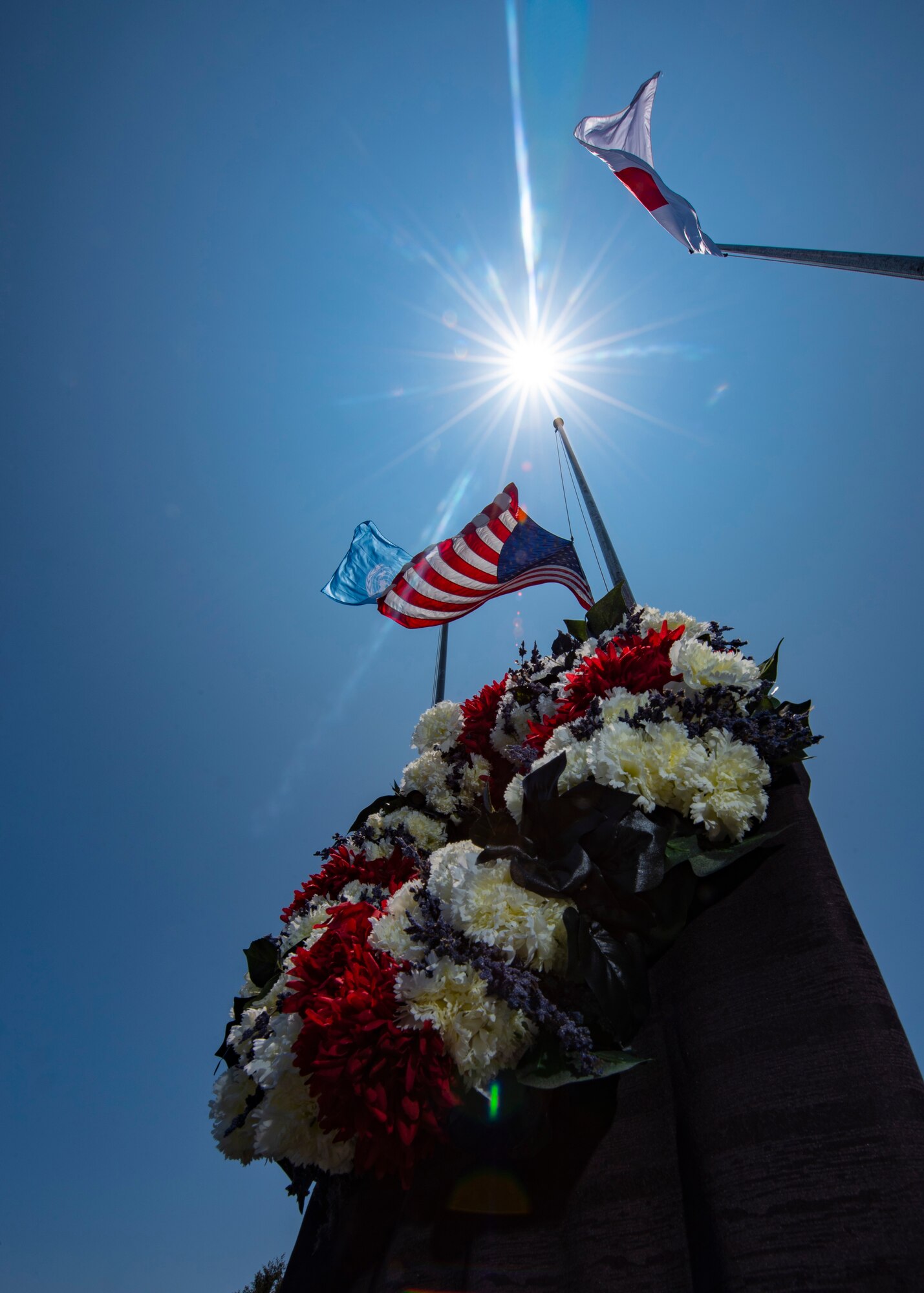 A wreath honoring the fallen sits at the base of an American flag after a Memorial Day ceremony May 25, 2018, at Kadena Air Base, Japan. Each year Memorial Day is held the last Monday of May to honor U.S. service members who paid the ultimate sacrifice for their country. (U.S. Air Force photo by Staff Sgt. Micaiah Anthony)