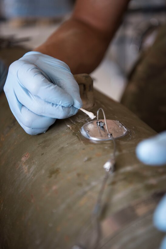 Airmen with the 332nd Expeditionary Maintenance Squadron Munitions Flight builds bombs for the F-15E at an undisclosed location in Southwest Asia May 19, 2018.
