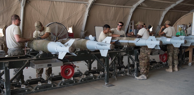 Airmen with the 332nd Expeditionary Maintenance Squadron Munitions Flight builds bombs for the F-15E at an undisclosed location in Southwest Asia May 19, 2018.