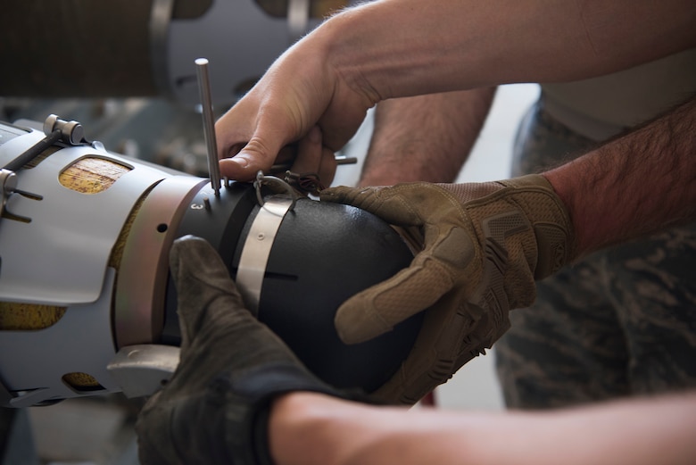 Airmen with the 332nd Expeditionary Maintenance Squadron Munitions Flight builds bombs for the F-15E at an undisclosed location in Southwest Asia May 19, 2018.