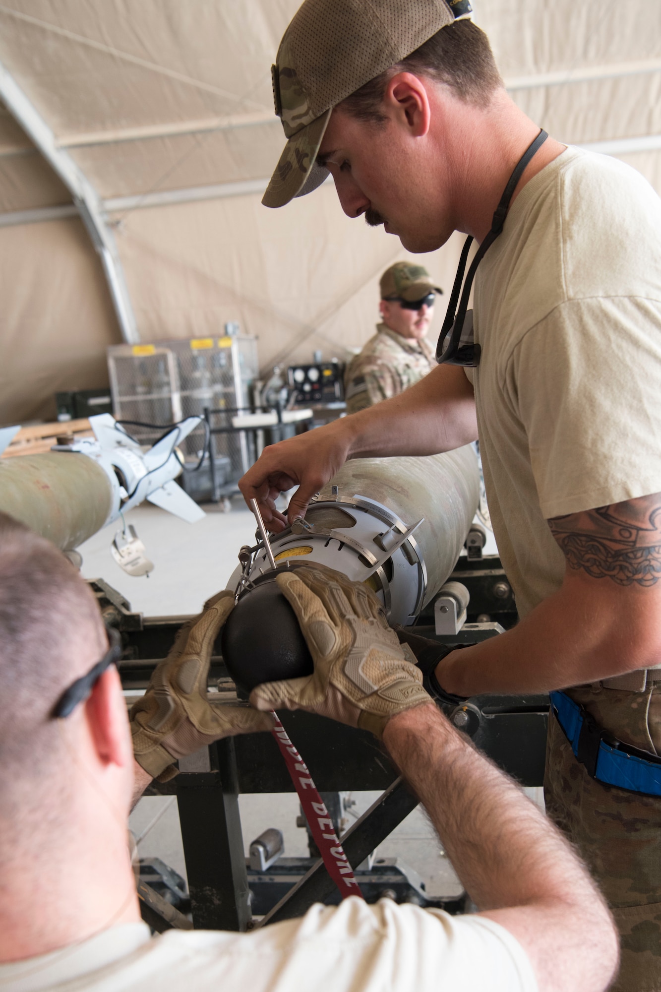 Airmen with the 332nd Expeditionary Maintenance Squadron Munitions Flight builds bombs for the F-15E at an undisclosed location in Southwest Asia May 19, 2018.