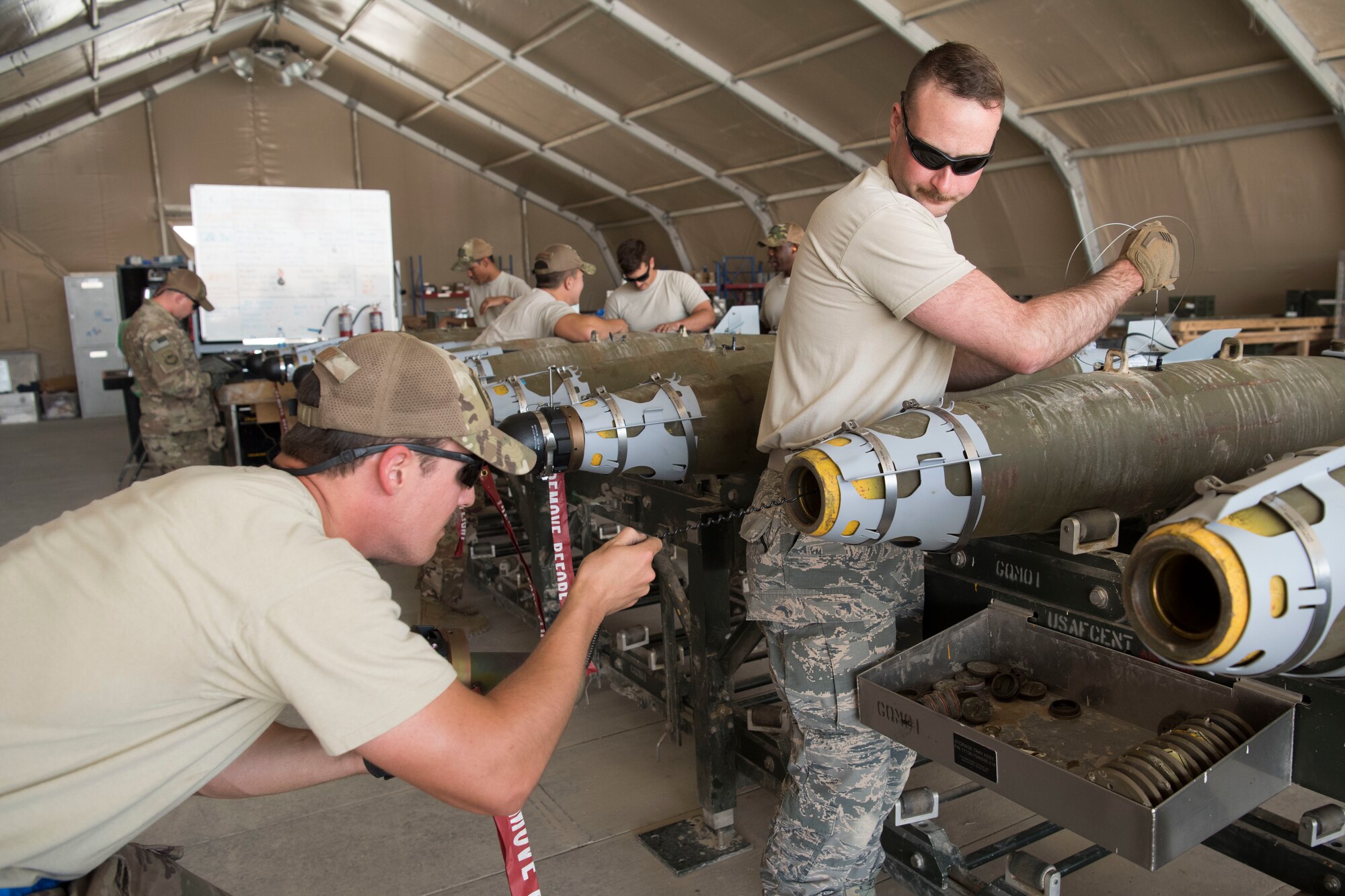 Airmen with the 332nd Expeditionary Maintenance Squadron Munitions Flight builds bombs for the F-15E at an undisclosed location in Southwest Asia May 19, 2018.