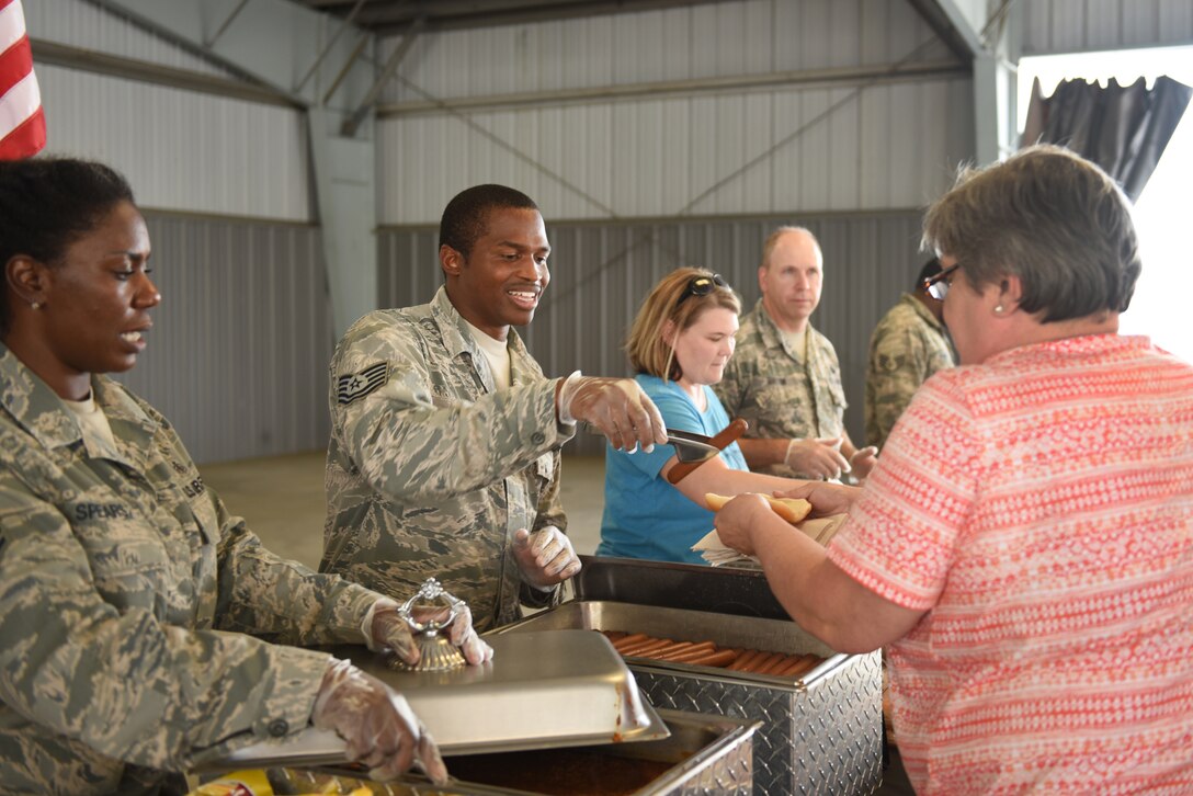 U.S. Air Force Tech. Sgts. Tah-Tah-Nisha Spears (far left), aerospace medical technician with the 145th Medical Group, and Eviat Hayes (center), avionics technician for the 145th Maintenance Squadron, serve food to participants and their families at the Z-Max Pavilion, Charlotte N.C., during the annual Special Olympics Day at the Races, May 24, 2018. The Special Olympics Day at the Races is an annual celebration held at the Lowes Motor Speedway and is put on by Vangie Boswell and fourteen sponsors including the North Carolina Air National Guard (NCANG). Members of the NCANG help set-up the event and pass out mementos while mingling with State Special Olympians and their families.(U.S. Air Force photo by Staff Sgt. Laura J. Montgomery/Released)