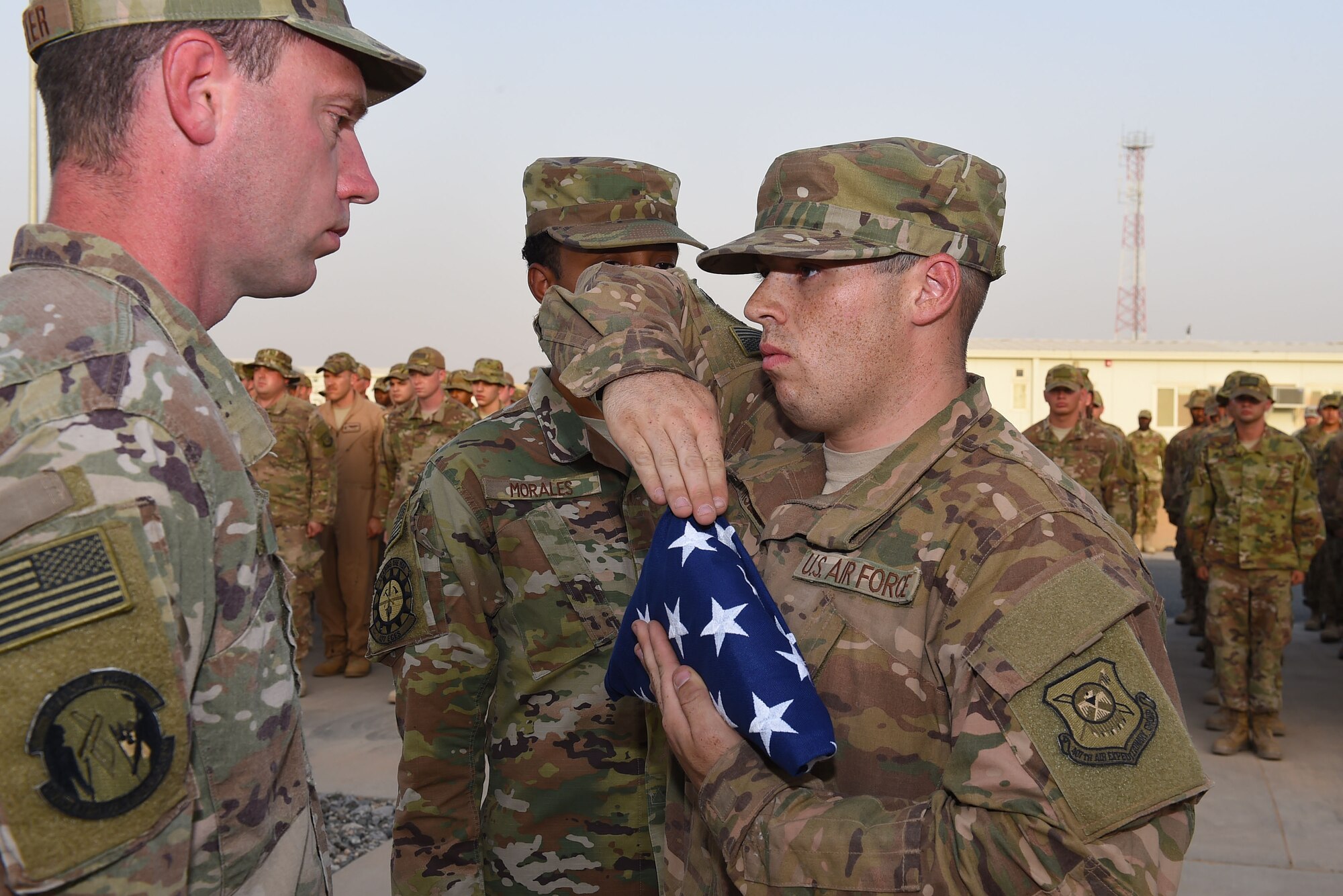 Members of the 407th Air Expeditionary Group honor guard prepare to "retire the colors" during a Memorial Day retreat ceremony, May 28, 2018.