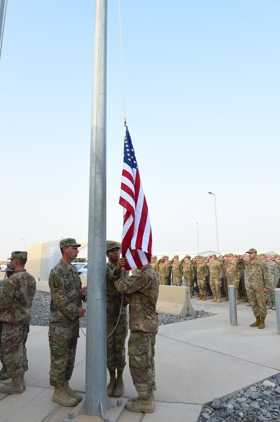 Members of the 407th Air Expeditionary Group honor guard retrieve the American flag during a Memorial Day retreat ceremony, May 28, 2018.