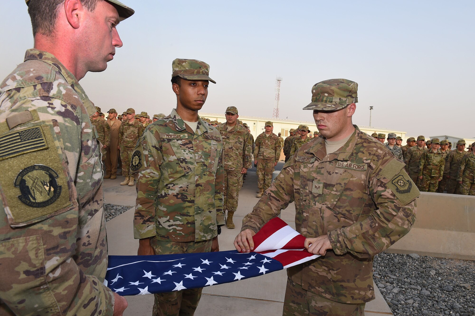Members of the 407th Air Expeditionary Group honor guard fold the American flag during a Memorial Day retreat ceremony, May 28, 2018.